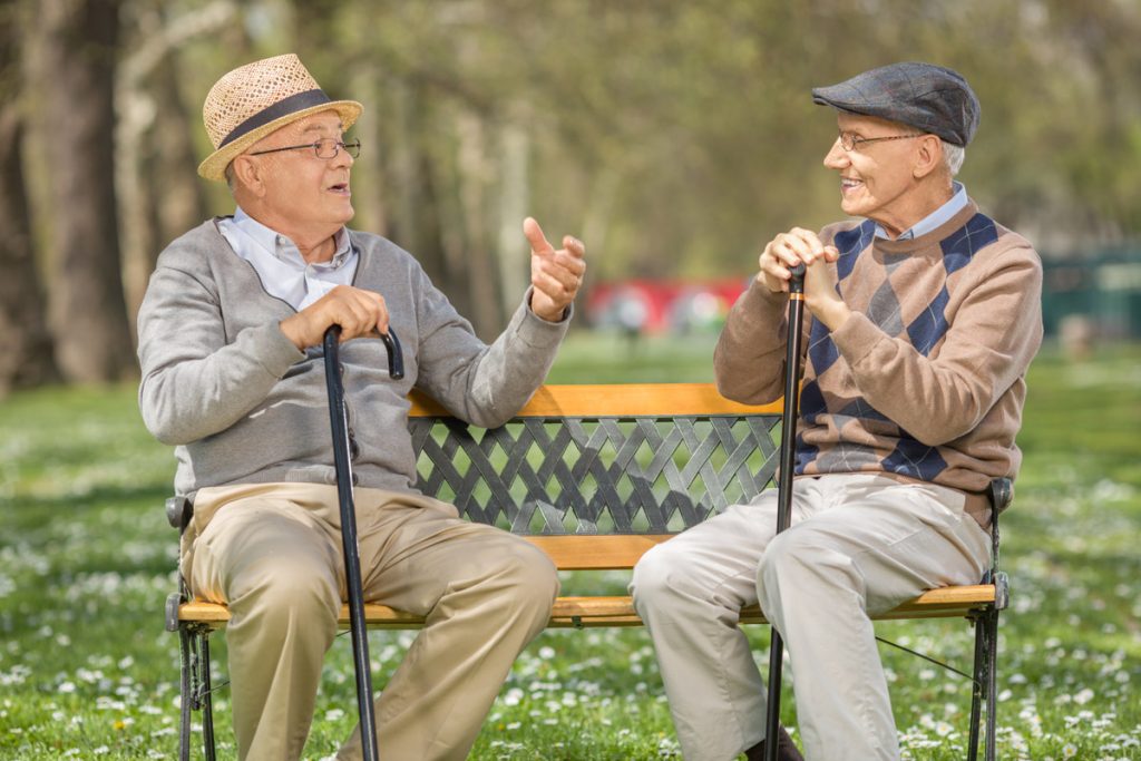Two men having a conversation on a bench to show face to face communication